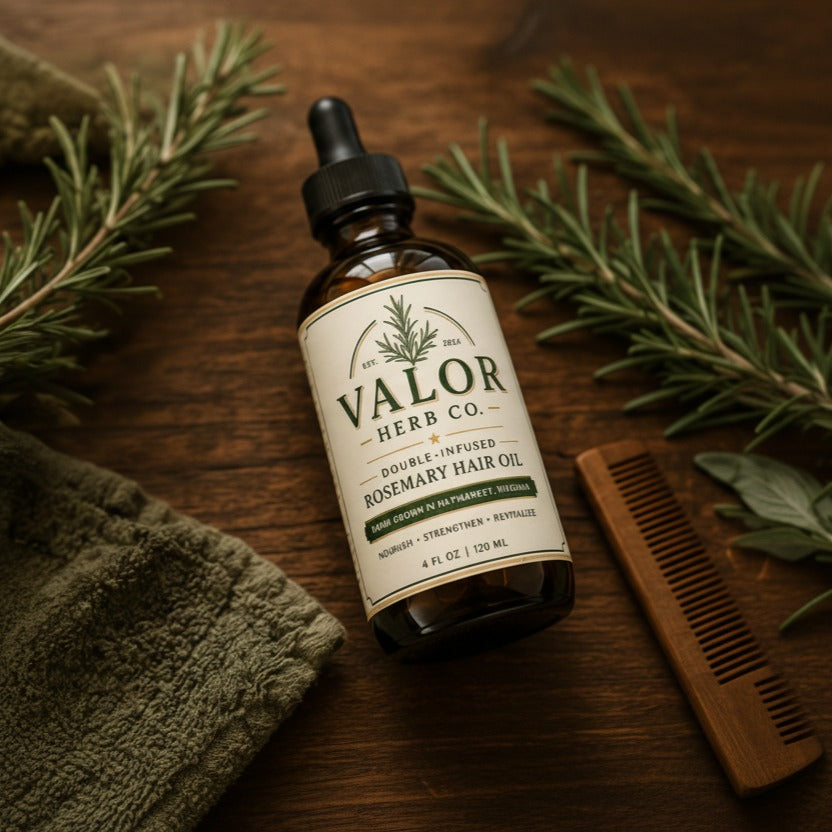 Bottle of Valor Herb Co. hair oil with a dropper on a wooden surface with greenery and a towel.